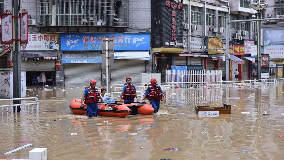 In this photo released by Xinhua News Agency, rescuers evacuate people stranded after flooding caused by heavy rain in the city of Jian'ou in southeast China's Fujian Province, June 19, 2022. (Huang Jiemin/Xinhua via AP)