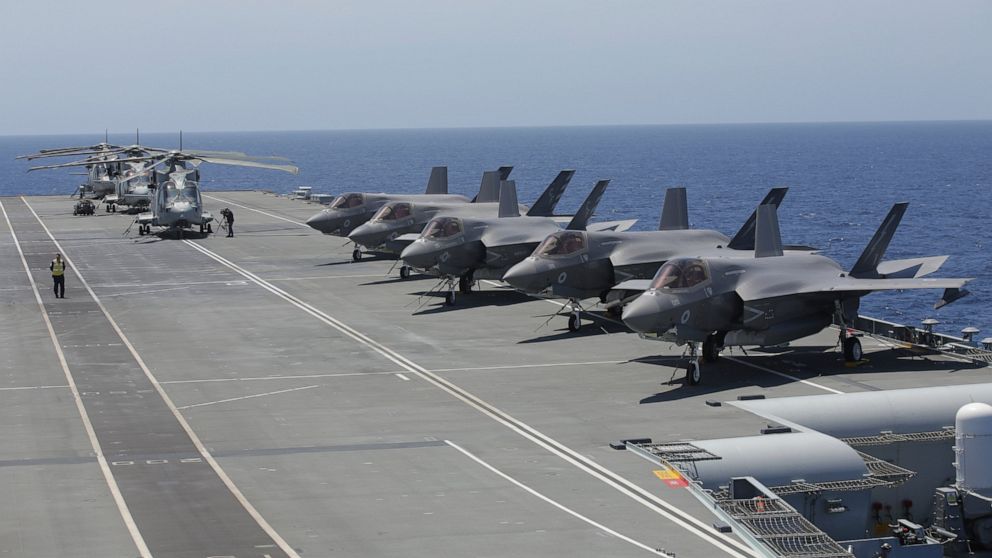 Military personnel inspect US and British jets as they participate in the NATO Steadfast Defender 2021 exercise on board the aircraft carrier HMS Queen Elizabeth off the coast of Portugal, Thursday, May 27, 2021. NATO has helped provide security in A