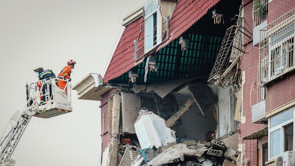 A fireman looks into the partially collapsed section of a building in China's Tianjin Municipality Tuesday, July 19, 2022. A gas explosion left some missing and others injured. (Chinatopix Via AP) CHINA OUT