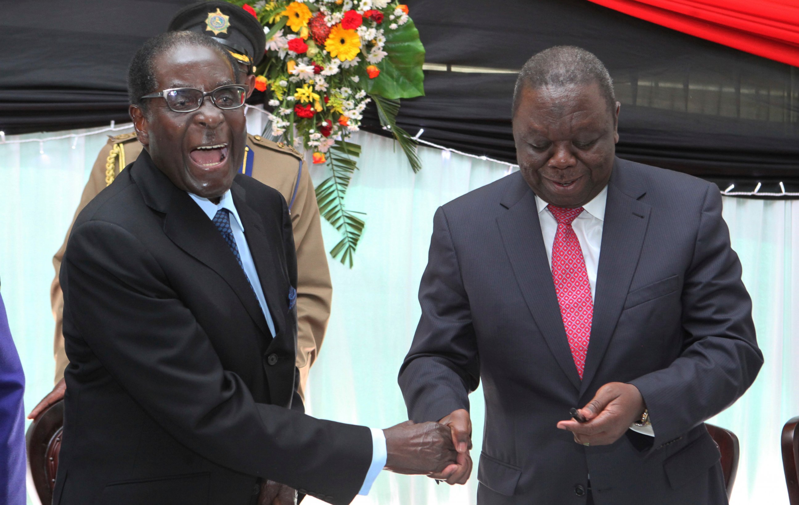 FILE - In this Wednesday, May 22, 2013 file photo Zimbabwean President Robert Mugabe, left, shakes hands with Prime Minister Morgan Tsvangirai after he signed the new constitution into law at State house in Harare. On Friday, Sept. 6, 2019, Zimbabwe 