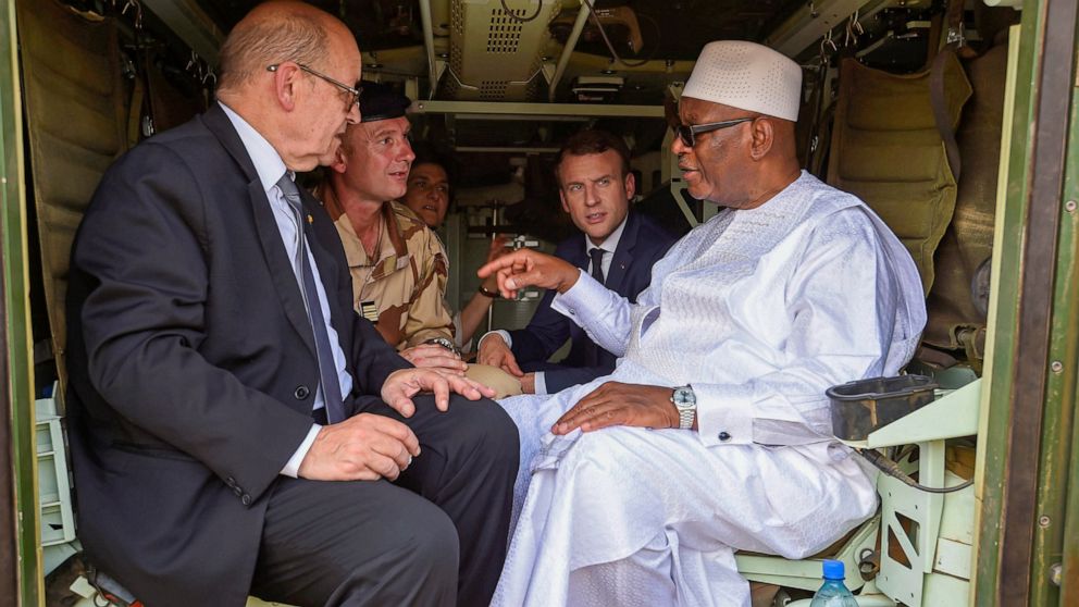 FILE — Mali's former President Ibrahim Boubacar Keita, right, speaks to French Foreign Affairs Minister Jean-Yves Le Drian, left, as French President Emmanuel Macron looks on, during their visit to soldiers of Operation Barkhane in Gao, Northern Mali