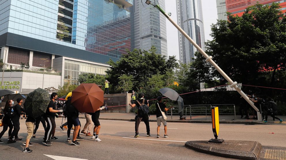 Demonstrators try to pull down a smart lamppost during a protest in Hong Kong, Saturday, Aug. 24, 2019. Chinese police said Saturday they released an employee at the British Consulate in Hong Kong as the city's pro-democracy protesters took to the st