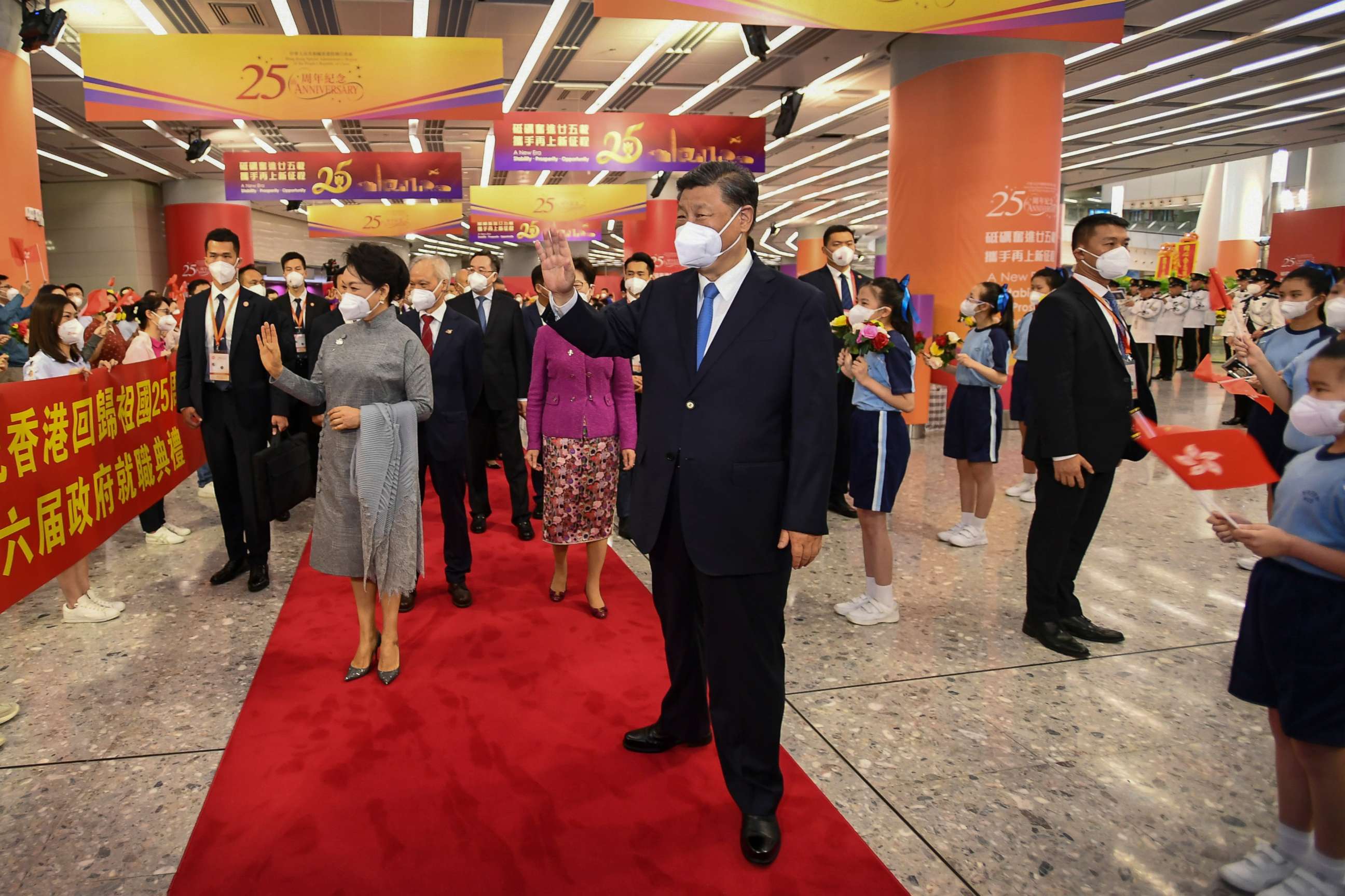 PHOTO: In this photo released by Xinhua News Agency, Chinese President Xi Jinping, center and his wife Peng Liyuan, center left, wave to welcoming crowd as they arrive to a train station in Hong Kong, Thursday, June 30, 2022.