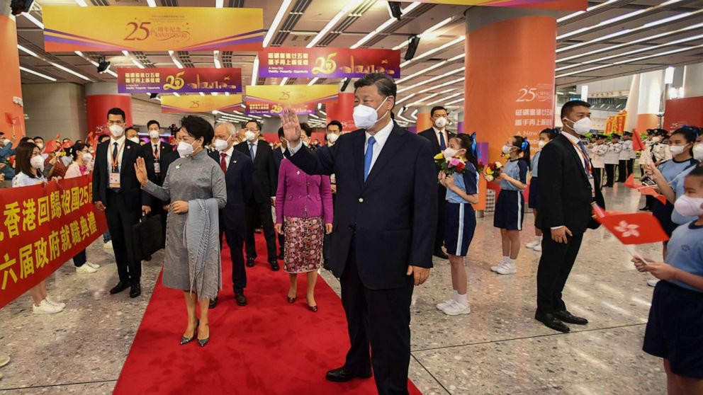PHOTO: In this photo released by Xinhua News Agency, Chinese President Xi Jinping, center and his wife Peng Liyuan, center left, wave to welcoming crowd as they arrive to a train station in Hong Kong, Thursday, June 30, 2022.