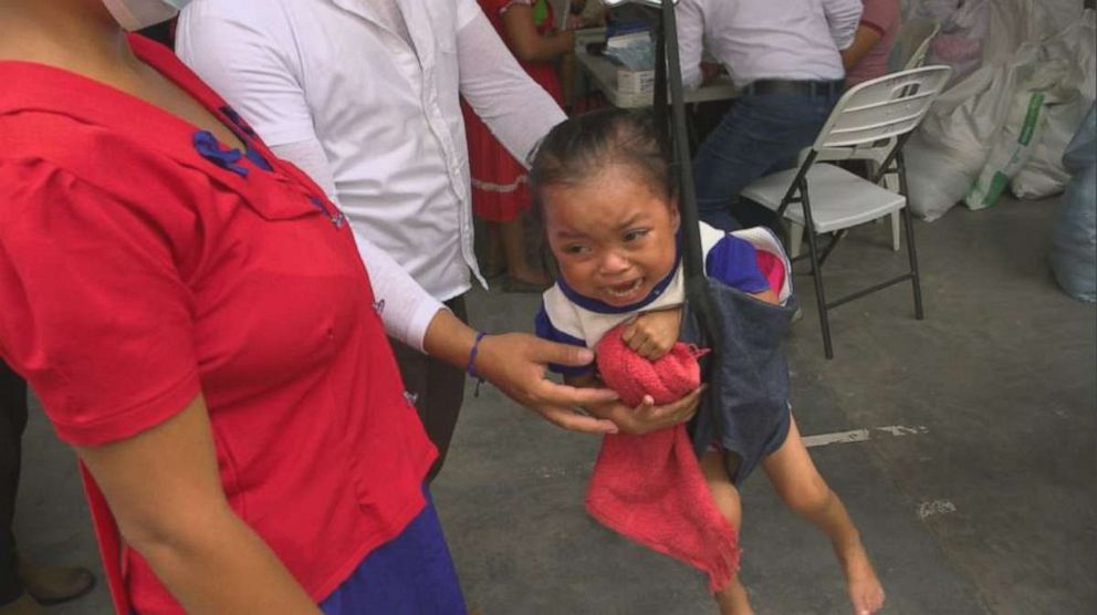 Little Anaeli being weighed in the village square in Jocotan, Guatemala.