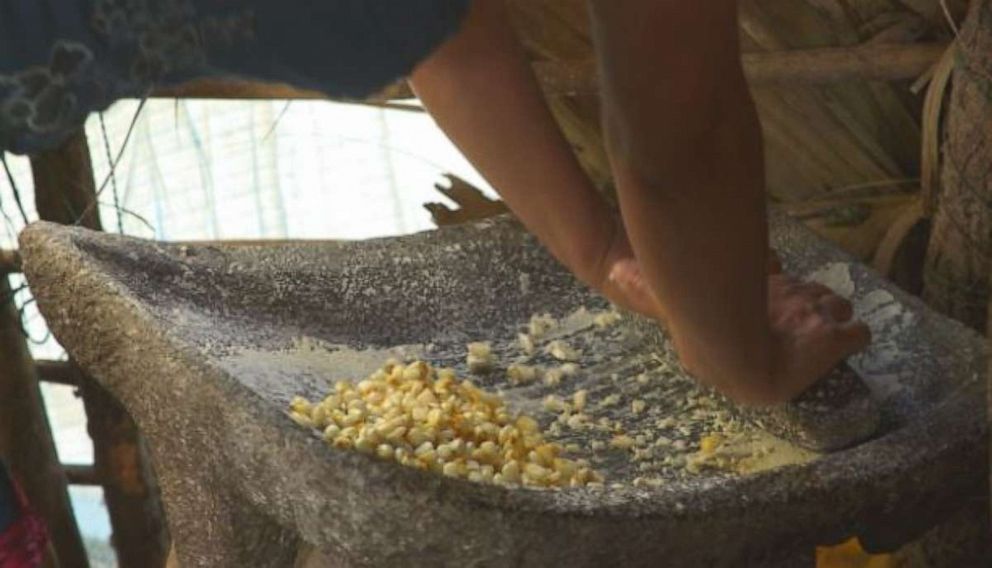 Jacinta is seen here grinding corn.