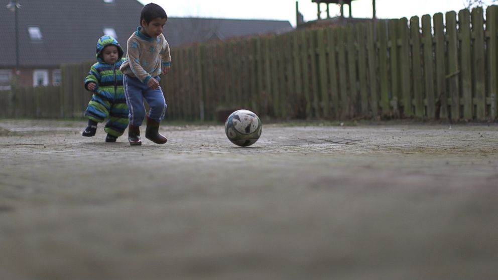 PHOTO: Houmideh and Fahed play soccer outside their new home in Hattstedt, Germany.