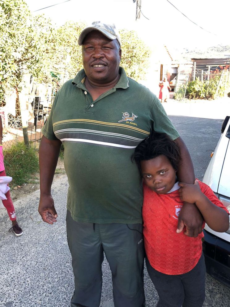 Julius Mulefe is seen here with one of his daughters. He's lived in a Cape Town township for 24 years.