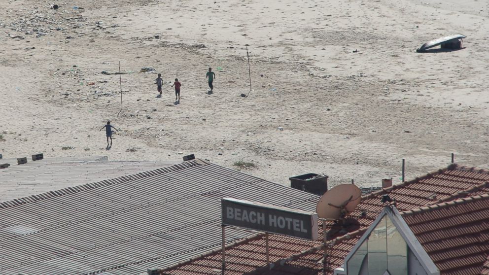 PHOTO: Four boys sprint across a beach in Gaza after the first blast from an Israeli shell.