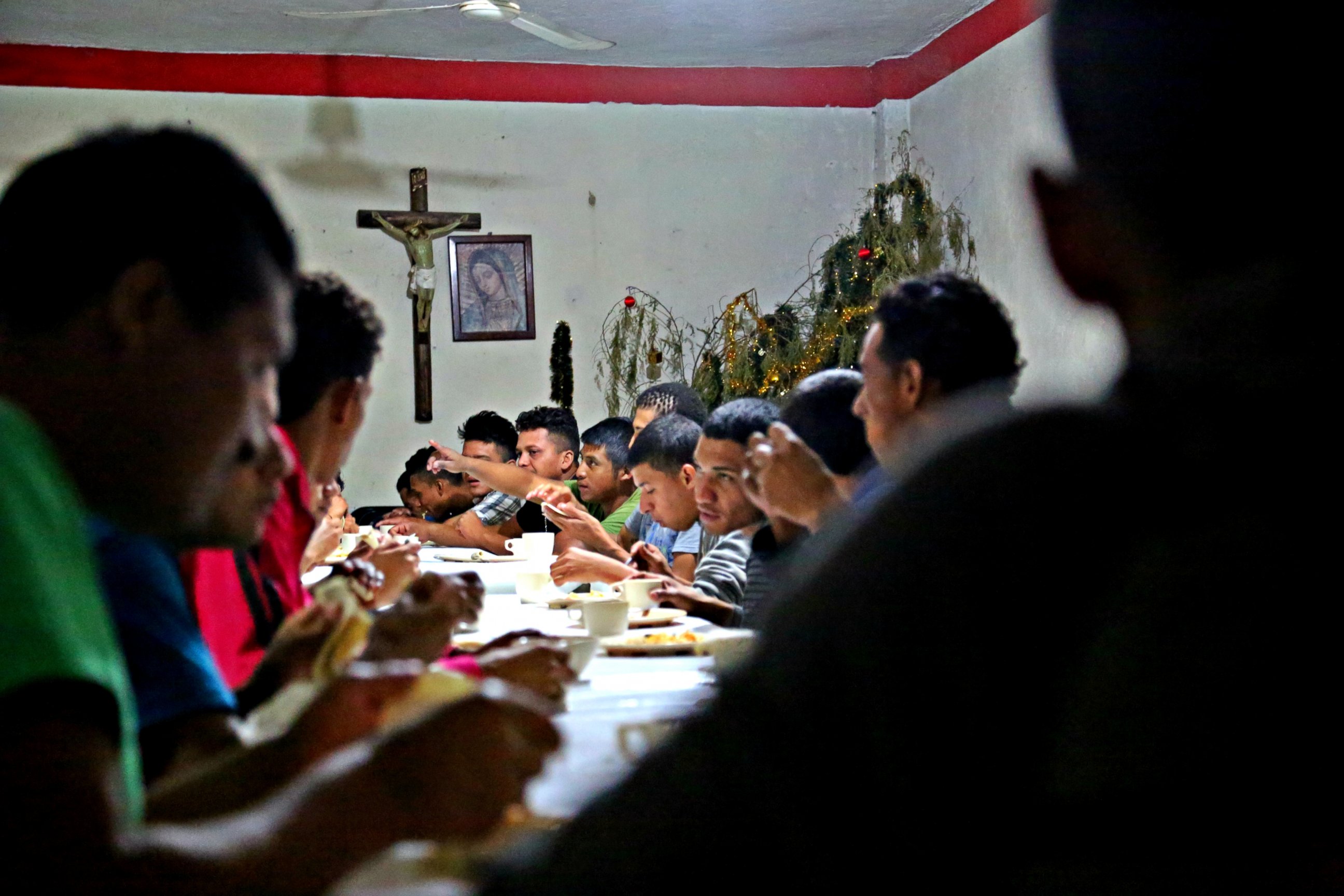 Volunteers from a nearby church stop by the shelters in Arriaga, Mexico to cook and pray with these young men. 
