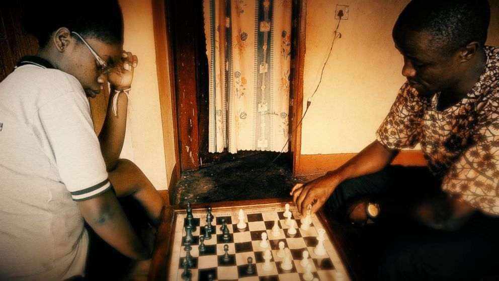 PHOTO:Phiona Mutesi and Robert Katende playing chess at the SOM Chess Academy.
