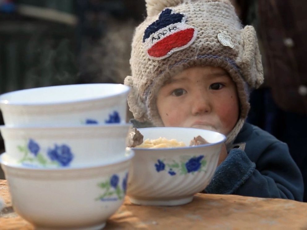 PHOTO: A young child eats lunch inside a Kashgar marketplace in Xinjiang, China in December 2015.