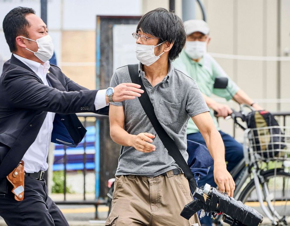 PHOTO: Tetsuya Yamagami, center, holding a weapon, is detained near the site of gunshots in Nara, western Japan, July 8, 2022. Yamagami is accused of assassinating former prime minister Shinzo Abe.
