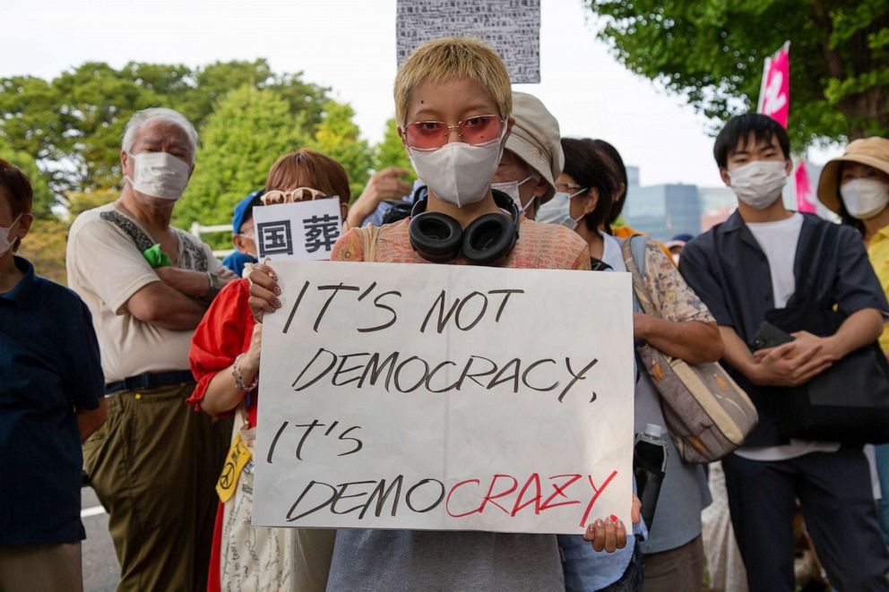 PHOTO: Demonstrators hold signs in protest of the state funeral being held, Sept. 27, 2022, in Japan for former Prime Minister, Shinzo Abe, in Tokyo.