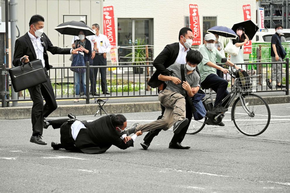 PHOTO: A man, believed to have shot former Japanese Prime Minister Shinzo Abe, is tackled by police officers in Nara, western Japan on July 8, 2022.