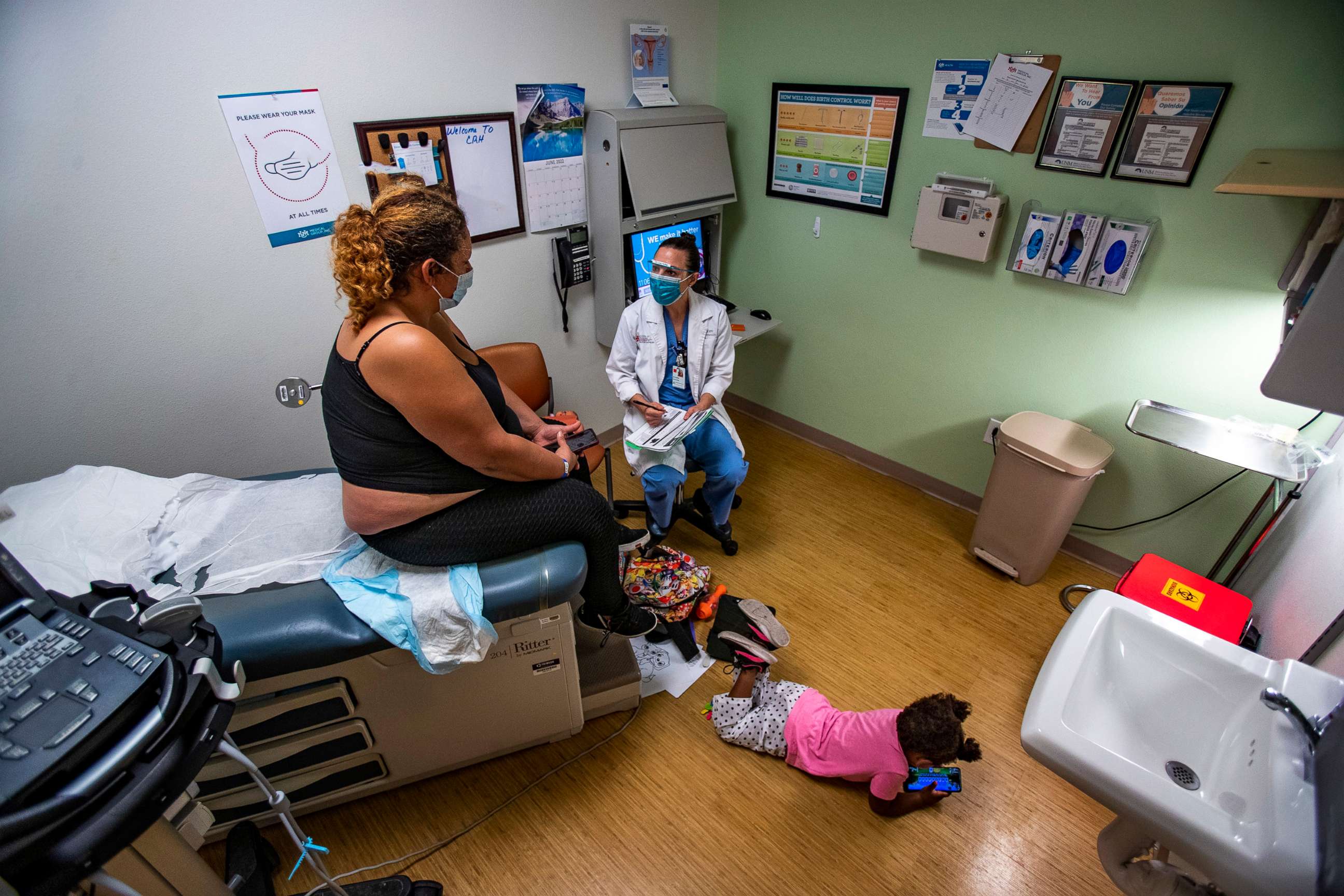 PHOTO: Dr. Lisa Hofler discusses the procedure for getting a medication abortion to patient while the patient's 3-year-old daughter plays on the floor of the Reproductive Center in Albuquerque, N.M., June 21m 2022.