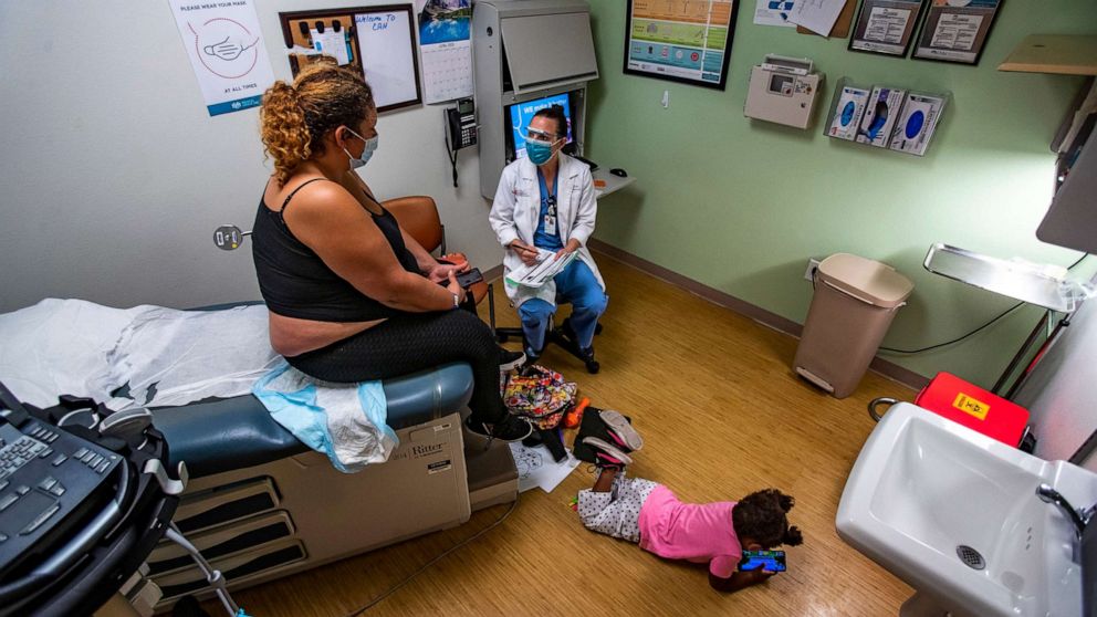 PHOTO: Dr. Lisa Hofler discusses the procedure for getting a medication abortion to patient while the patient's 3-year-old daughter plays on the floor of the Reproductive Center in Albuquerque, N.M., June 21m 2022.