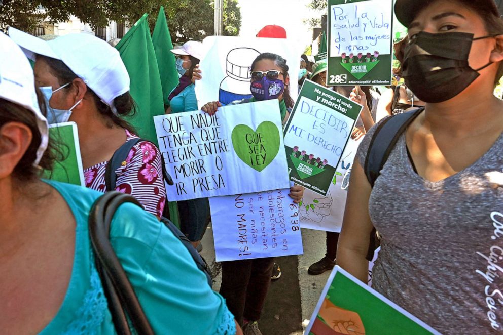 PHOTO: Abortion rights demonstrators hold placards, on saying "Que nadie tenga que elegir entre morir o ir presa; Que sea ley" ("No one should have to chose between dying or going to jail; Make it law") in San Salvador, El Salvador, on Sept. 28, 2021.