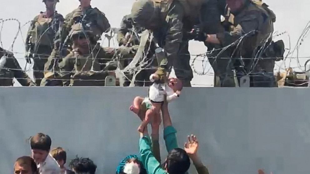 PHOTO: A baby is handed over to the American army over the perimeter wall of the airport for it to be evacuated, in Kabul, Aug. 19, 2021.