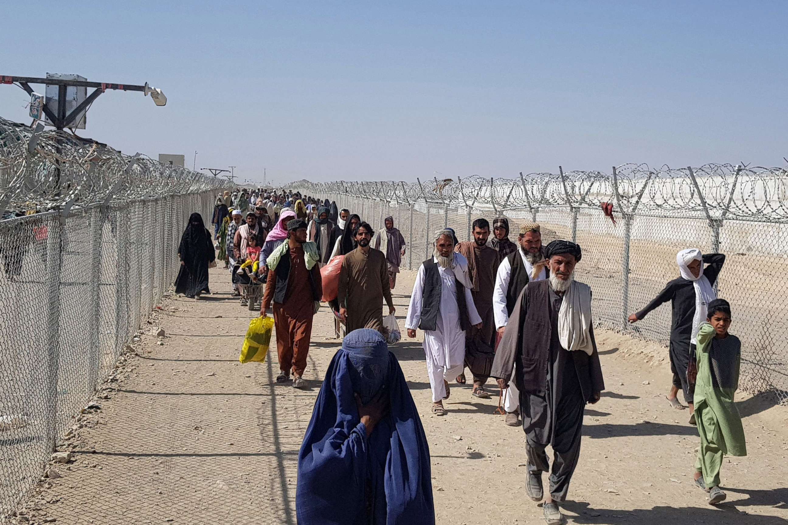 PHOTO: Afghan nationals cross the border into Pakistan at the Pakistan-Afghanistan border crossing in Chaman, Aug. 18, 2021.