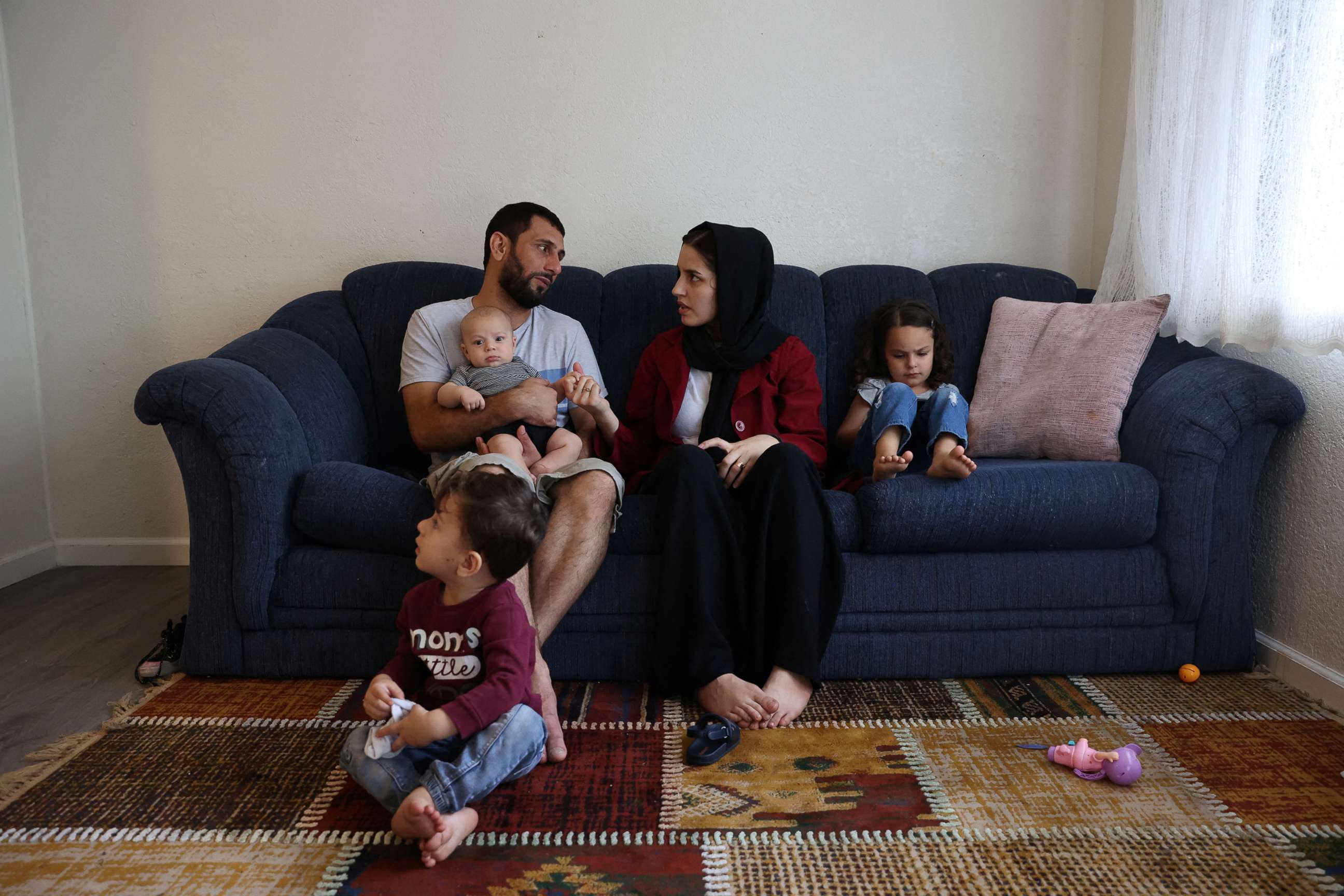 PHOTO: The Mohammadi family, Najib holding Yusuf, Yasar, Susan and Zahra, sit together in their living room, at their home in Sacramento, Calif., Aug. 1, 2022.