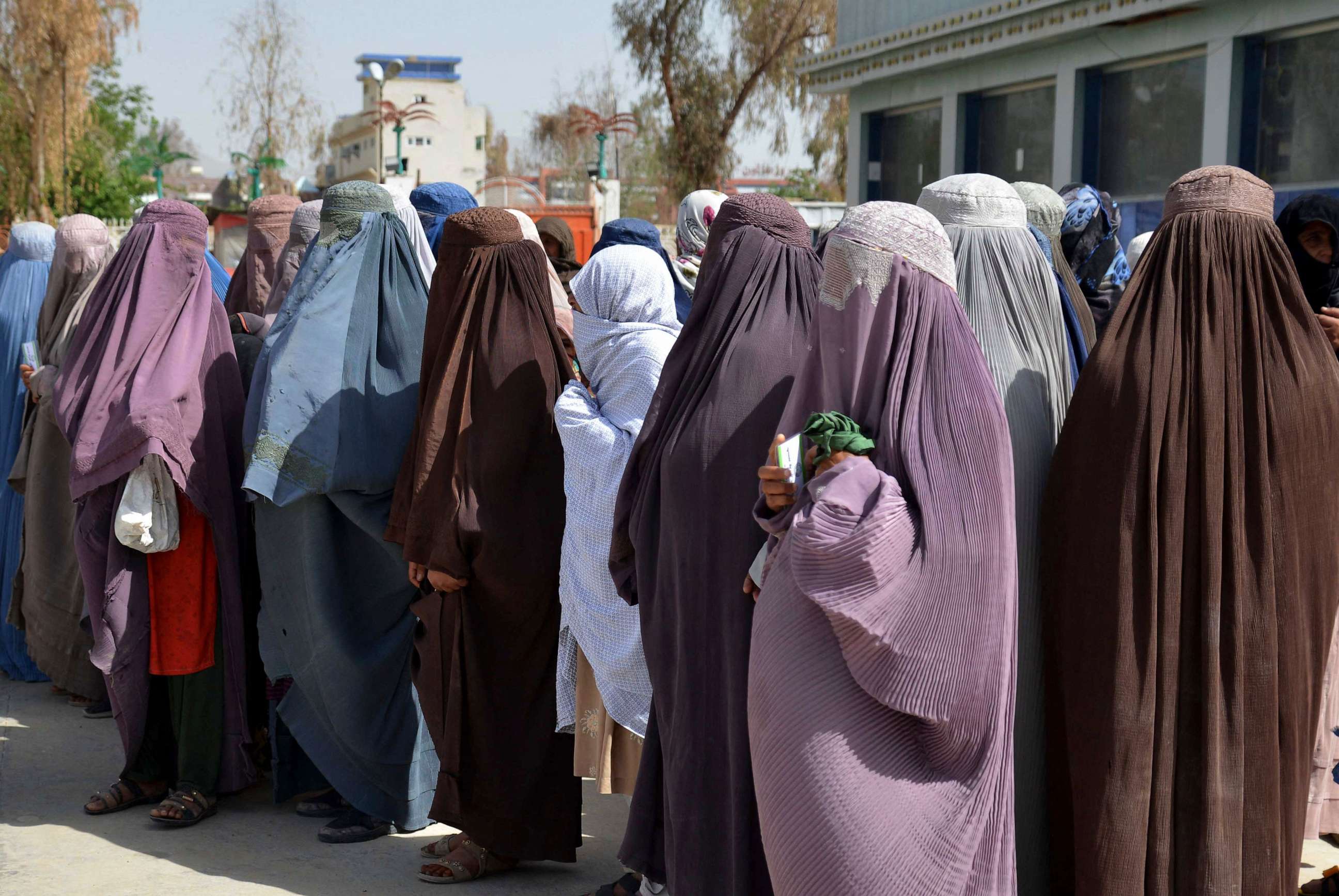 PHOTO: Afghan women stand on a queue to receive food aid distributed by a charity foundation during the Muslim holy fasting month of Ramadan in Kandahar on March 28, 2023.