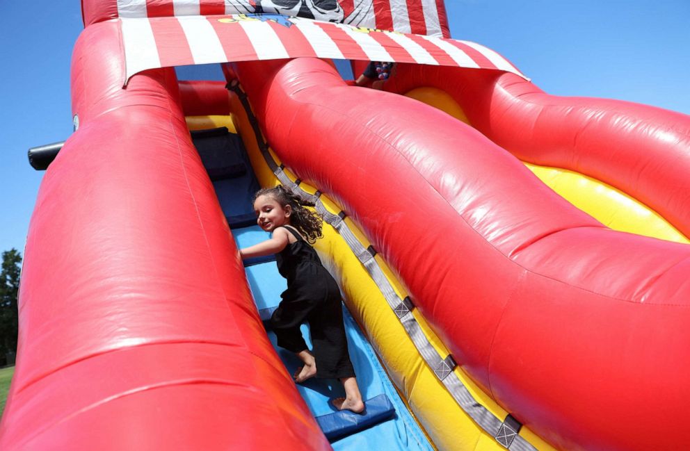 PHOTO: Zahra Mohammadi, 3, climbs an inflatable slide at a Fourth of July celebration in Sacramento, Calif., July 4, 2022.