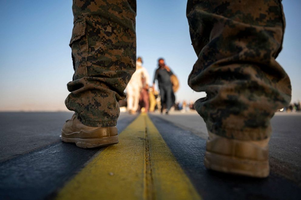 PHOTO: A U.S. Marine provides security for evacuees boarding a U.S. Air Force C-17 at Hamid Karzai International Airport, in Afghanistan, Aug. 24, 2021.