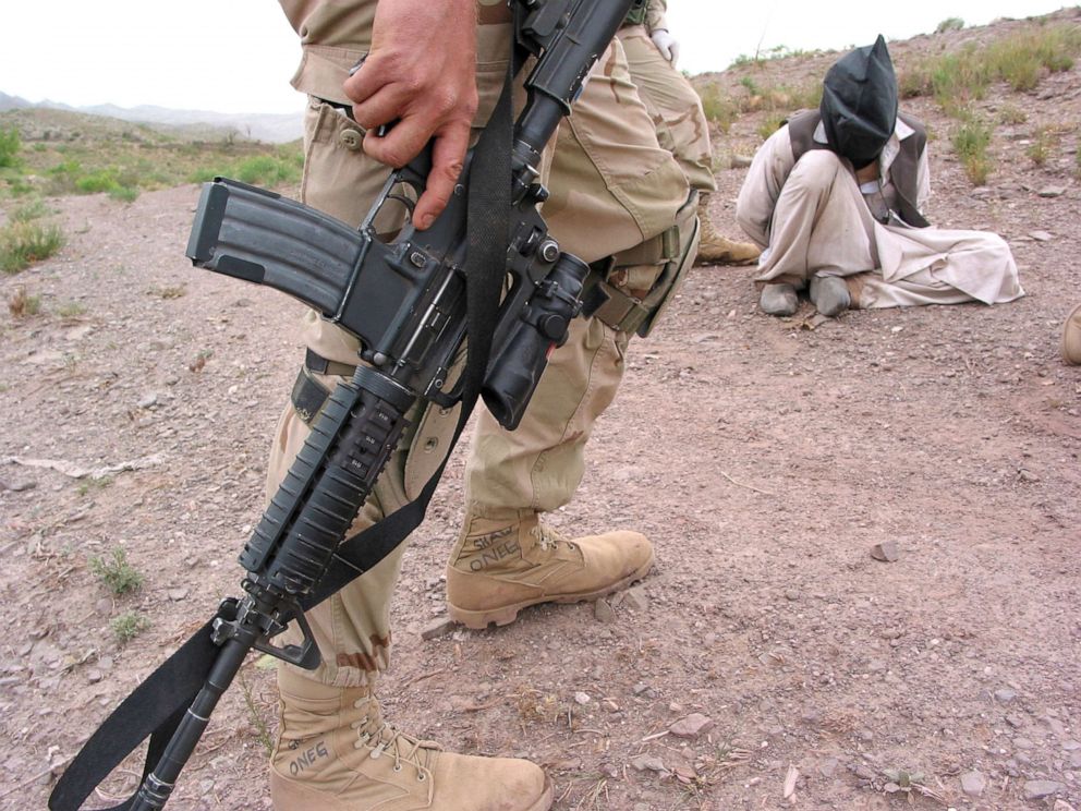 PHOTO: A member of the U.S. 82nd Airborne Division stands guard over a prisoner, during Operation Dragon Fury eastern Afghanistan in 2003. The operation in the Showi Kowt Mountains, was launched to hunt down suspected al-Qaeda and Taliban militants. 