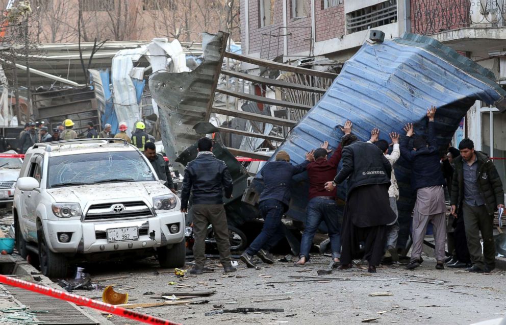 PHOTO: People try to remove debris from the scene of a suicide bomb attack in Kabul, Afghanistan, Jan. 27, 2018.