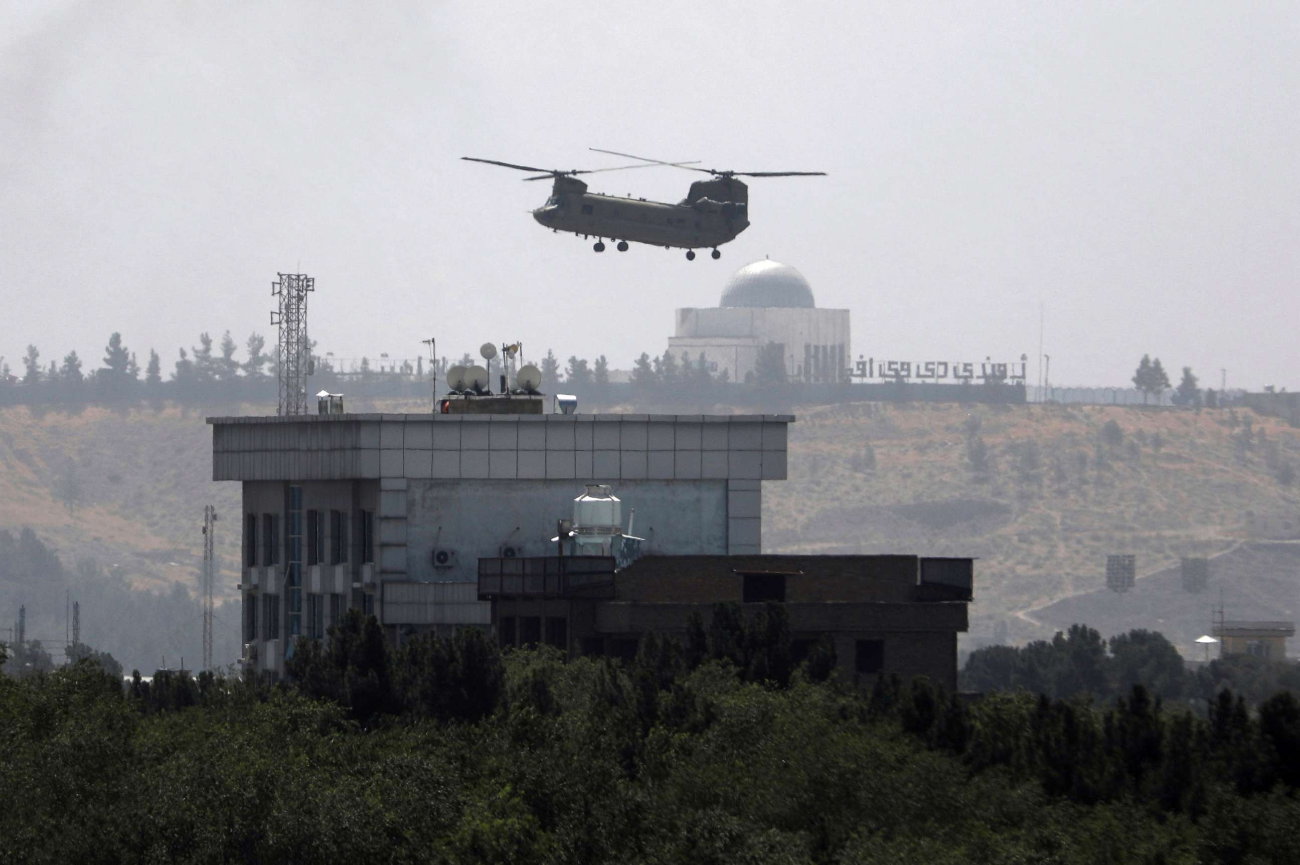 PHOTO: A U.S. Chinook helicopter flies over the U.S. Embassy in Kabul, Afghanistan,   Aug. 15, 2021. Helicopters are landing at the U.S. Embassy in Kabul as diplomatic vehicles leave the compound amid the Taliban advanced on the Afghan capital. 