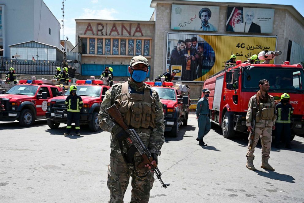 PHOTO: Afghan policemen stand guard as they wait for the firefighters from the government emergency committee to arrive for spraying disinfectant on a street as a preventive measure against the spread of COVID-19, in Kabul, June 18, 2020.