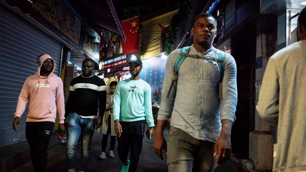 PHOTO: FILE PHOTO: People walk in the "Little Africa" district in Guangzhou, the capital of southern China's Guangdong province, March 1, 2018.