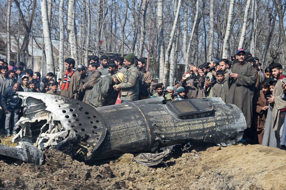 PHOTO: Indian soldiers and Kashmiri onlookers stand near the remains of an Indian Air Force helicopter after it crashed in Budgam district, on the outskirts of Srinagar on Feb. 27, 2019.