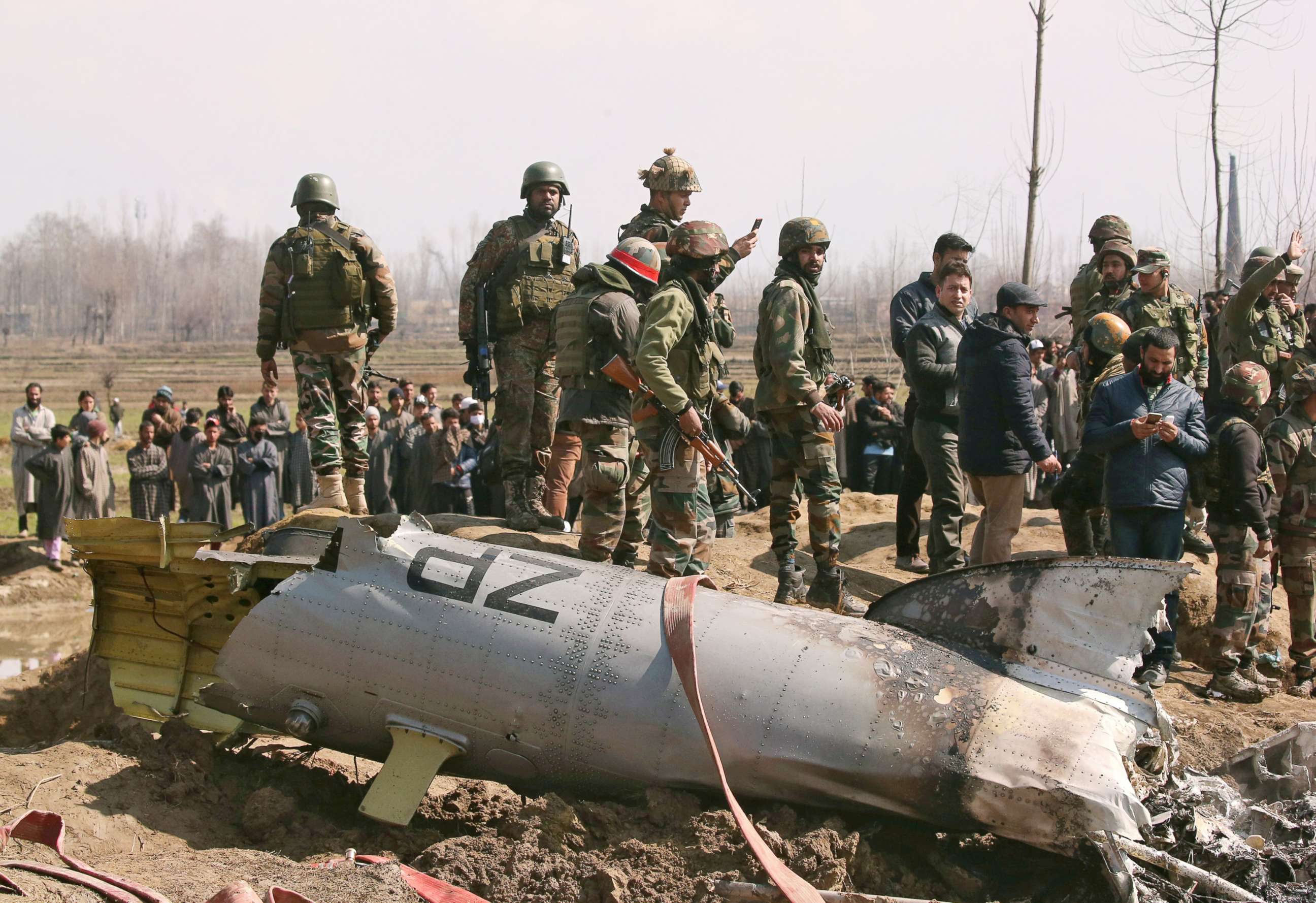 PHOTO: Indian soldiers stand next to the wreckage of an Indian Air Force helicopter after it crashed in Budgam district in Kashmir Feb. 27, 2019.