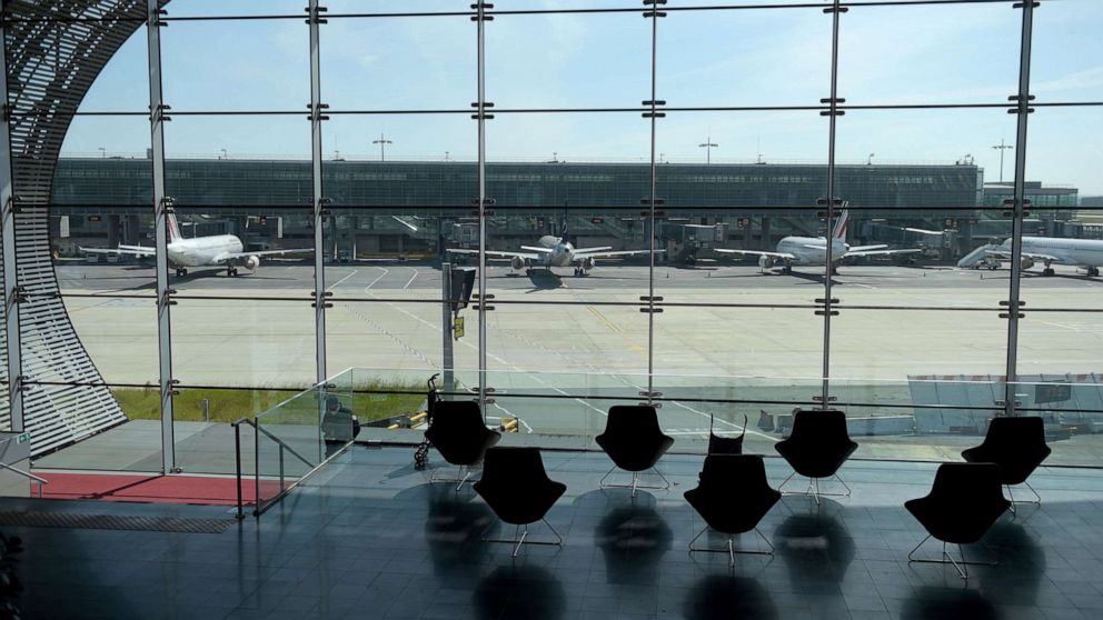 PHOTO: (FILES) This file photo taken on May 12, 2020, through a window shows planes on the tarmac at the Terminal 2E at the Paris-Charles de Gaulle airport in Roissy-en-France. 
