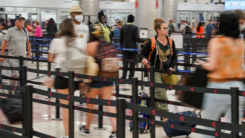 PHOTO : Les passagers franchissent le point de contrôle de sécurité avant leur vol à l'aéroport international Hartsfield-Jackson d'Atlanta à Atlanta, le 28 juin 2022. 