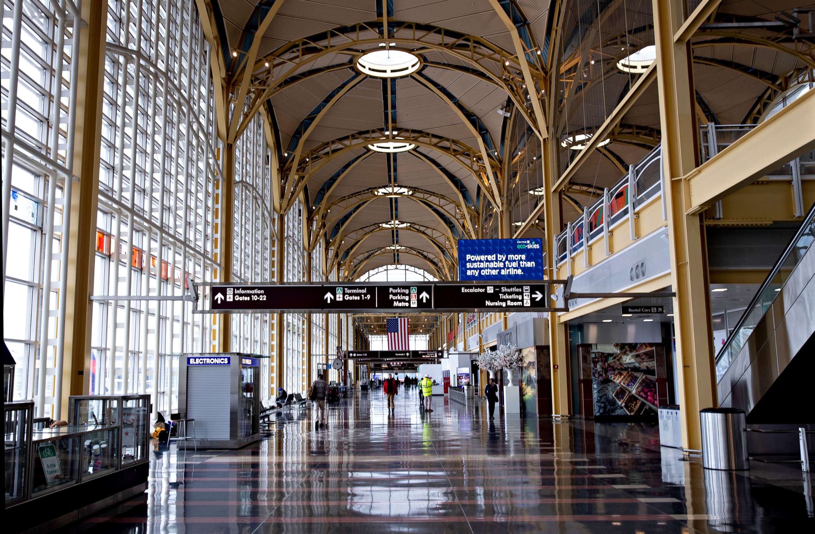 PHOTO: A handful of travelers are seen at the largely-empty Ronald Reagan Washington National Airport in Arlington, Va., due to the coronavirus pandemic, March 25, 2020. 