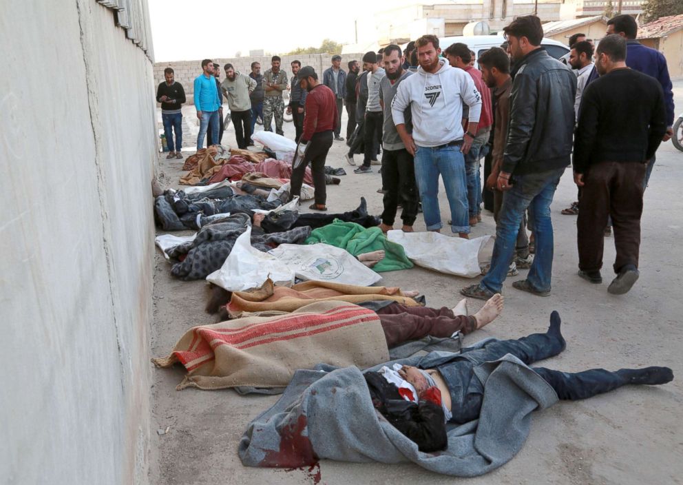 PHOTO: People gather next to bodies following a reported airstrike on the rebel-held town of Atareb in Syria's northern Aleppo province, Nov. 13, 2017.