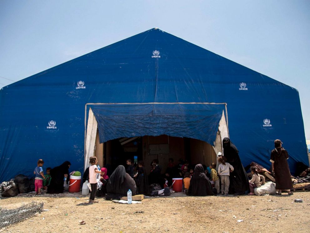 PHOTO: Women and children related to fighters of the Islamic State group wait to board buses and trucks, leaving the overcrowded al-Hol camp to return to their homes, June 3, 2019, in Hasakeh, Syria.