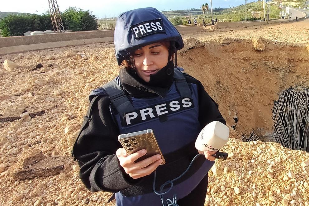 PHOTO: Amal Khalil, a Lebanese journalist working for the daily Al-Akhbar newspaper, reports near a destroyed bridge in Qasmiyeh, Lebanon, March 22, 2026.