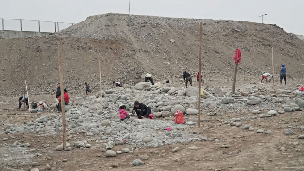 PHOTO: Once home to 238 families, displaced indigenous Shipibos dig up rocks and debris to erect tarp huts in their Lima slum of Cantagallo.