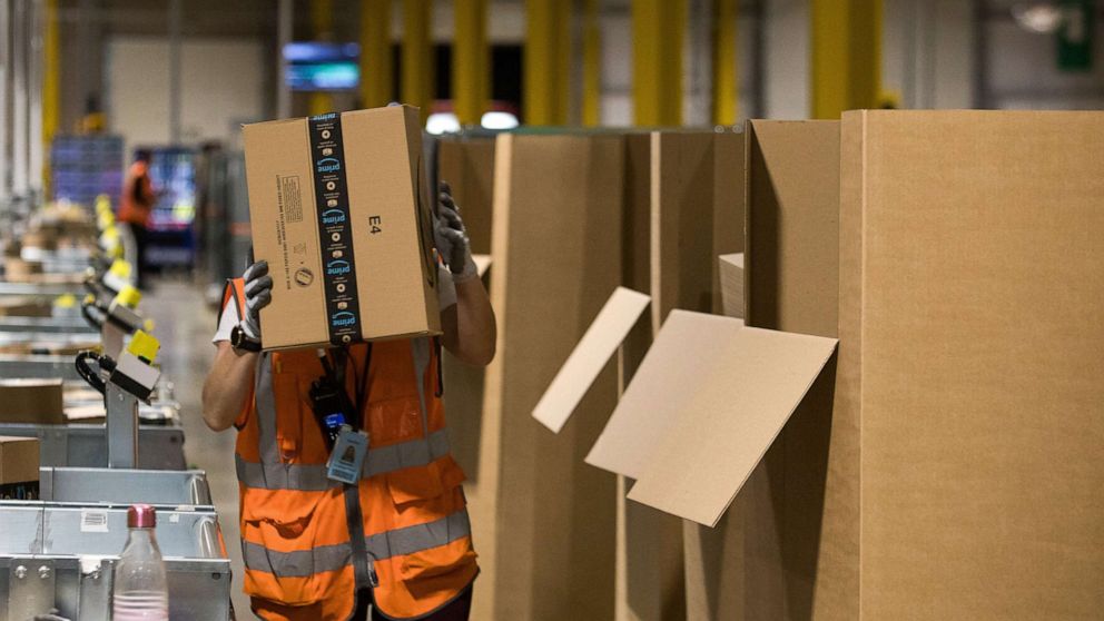 PHOTO: An employee places a package into a box at an Amazon.com Inc. fulfillment center in Kegworth, U.K., Oct. 12, 2020. 
