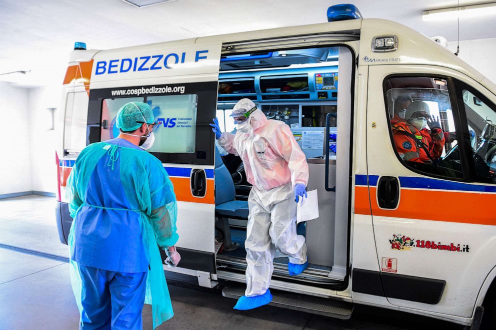 PHOTO: A medical worker wearing a face mask brings a patient in an ambulance arriving at the new coronavirus intensive care unit of the Brescia Poliambulanza hospital in northern Italy's Lombardy region on March 17, 2020.