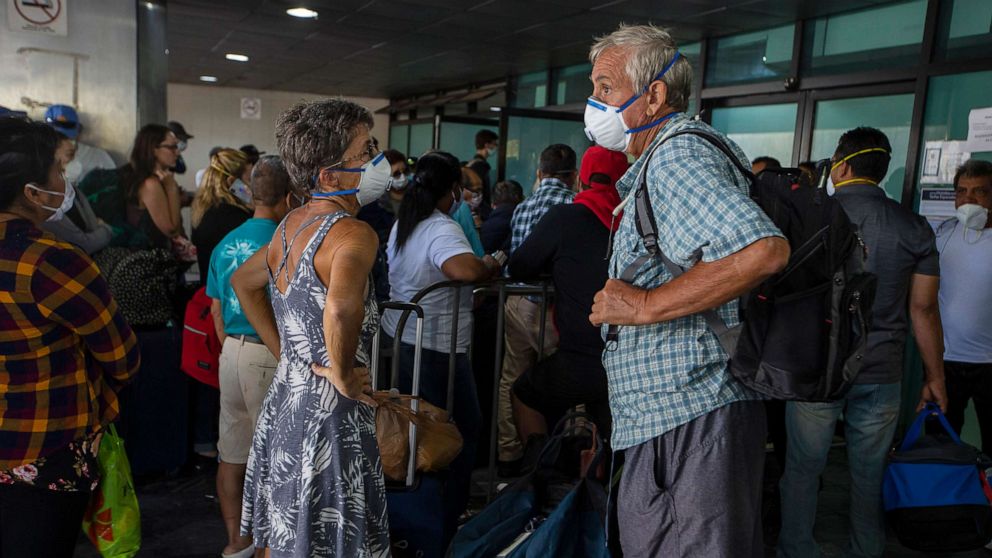 PHOTO: Travelers wait for a charter flight coordinated by the U.S. embassy at the La Aurora airport in Guatemala City, Tuesday, March 24, 2020.