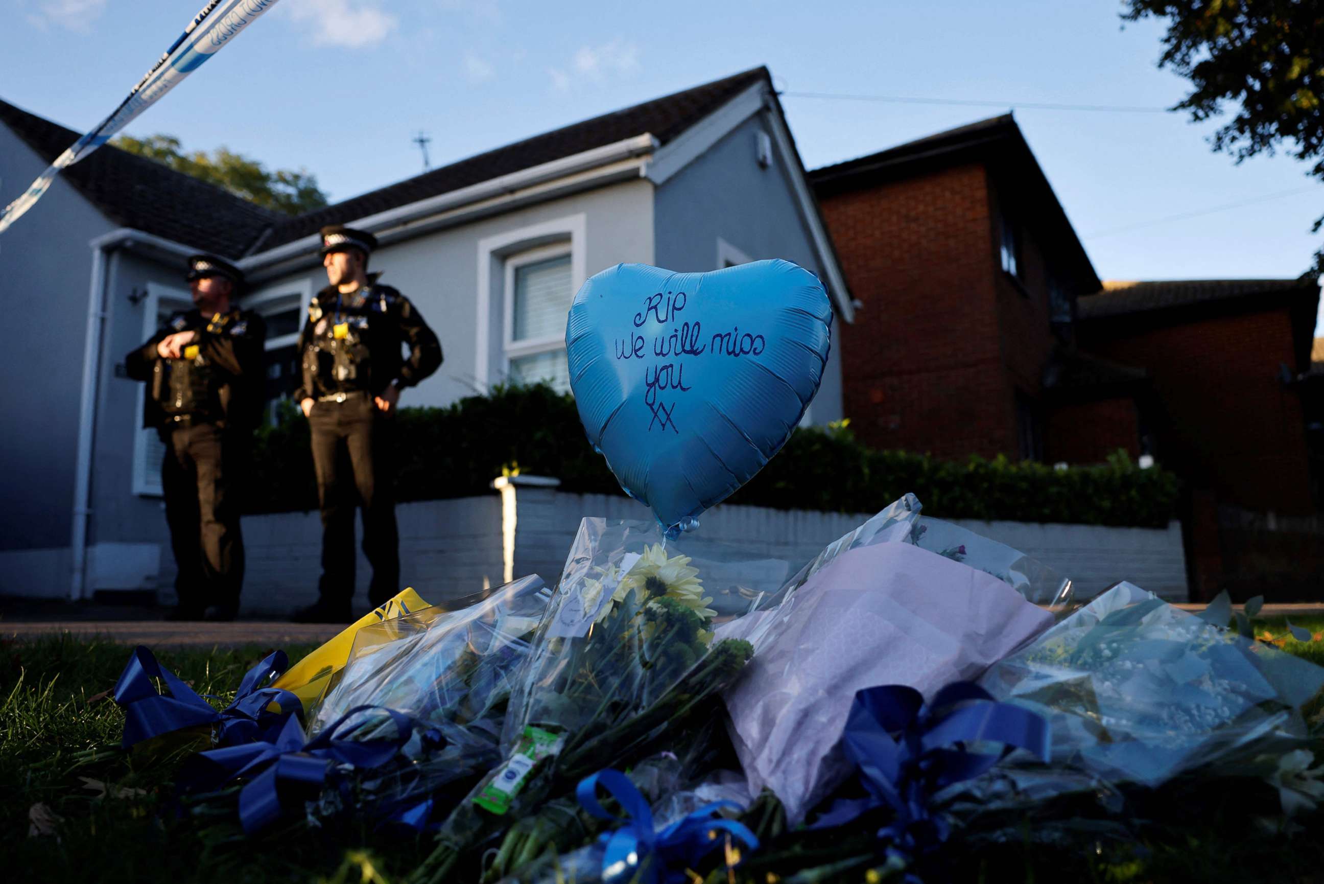 PHOTO: Floral tributes are placed near the scene of a fatal stabbing of British lawmaker David Amess, as police stand guard near the Belfairs Methodist Church in Leigh-on-Sea, in southeast England, Oct. 15, 2021.