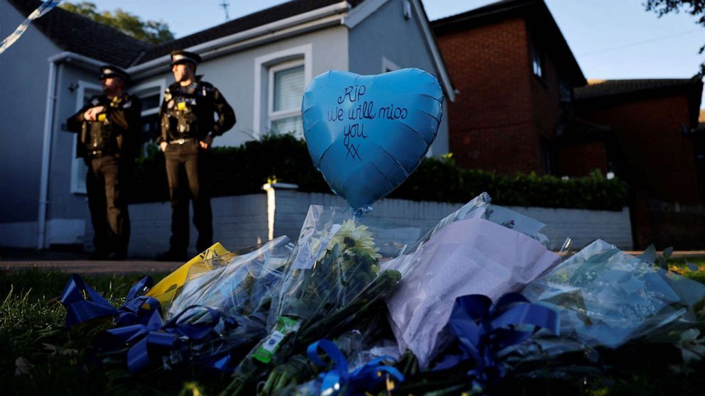 PHOTO: Floral tributes are placed near the scene of a fatal stabbing of British lawmaker David Amess, as police stand guard near the Belfairs Methodist Church in Leigh-on-Sea, in southeast England, Oct. 15, 2021.