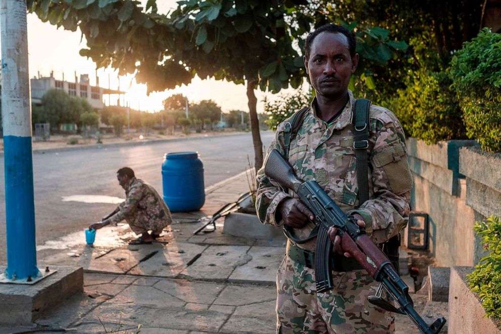 PHOTO: A member of the Amhara Special Forces, aligned with the Ethiopian government, holds his gun while another washes his face in Humera, Ethiopia, on Nov. 22, 2020.