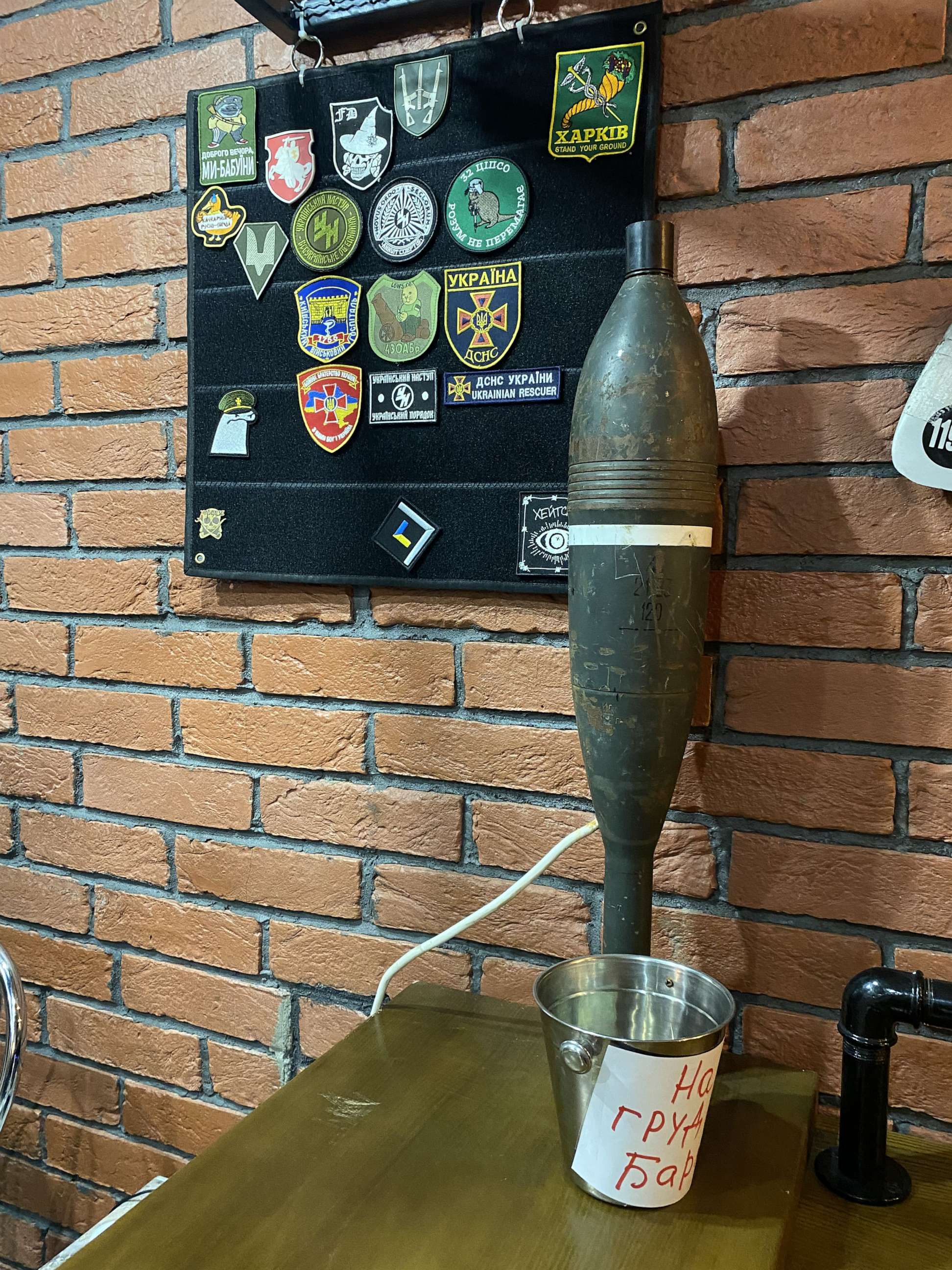 PHOTO: At Offensive, a new bar in Kyiv, Ukraine, patrons eat and drink among ammo, chevrons and other items representing the country's fight against the Russian invasion.