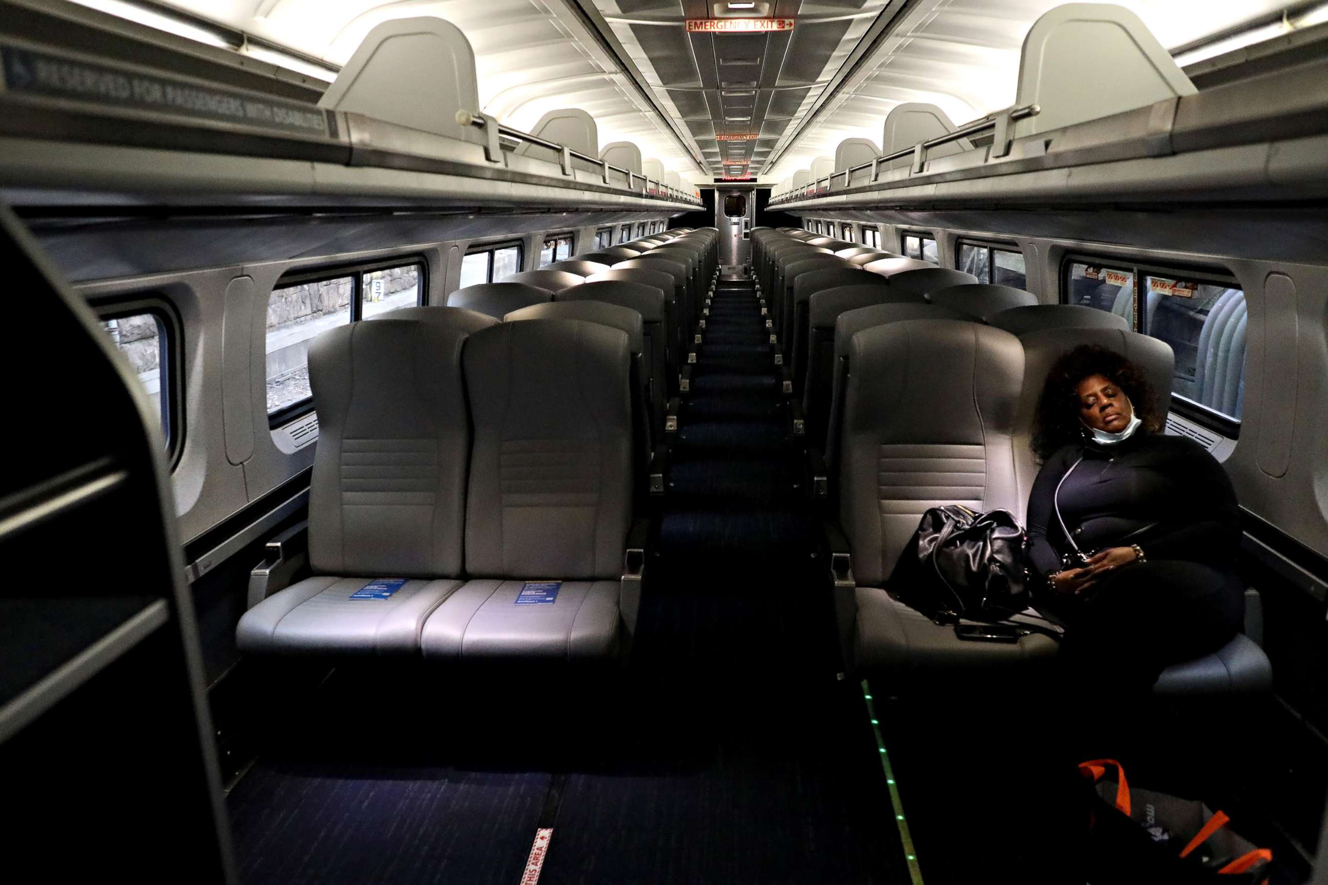 PHOTO: A lone passenger sleeps in an empty Amtrak car as the train pulls into Penn Station, on April 9, 2020, in Baltimore.